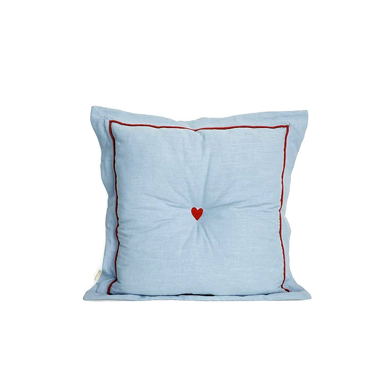 Light blue cushion with a red heart on a white background