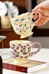 Floral twisted-handle ceramic mug by TRLab Shop featuring colorful floral pattern and ergonomic twisted handle.
