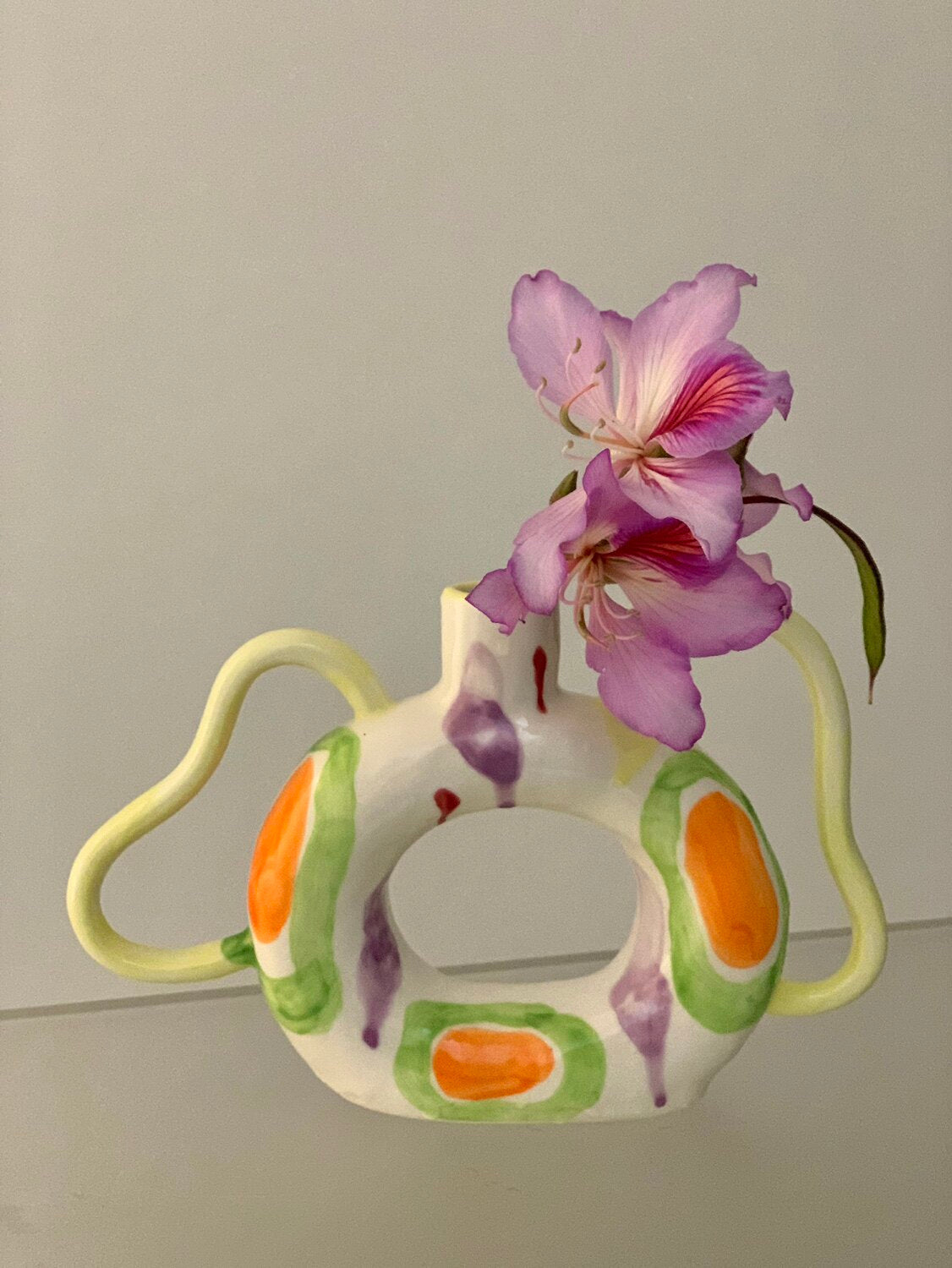 Ceramic donut-shaped twin-handled vase from UNBELDI collection, featuring a modern design and smooth glazed finish.